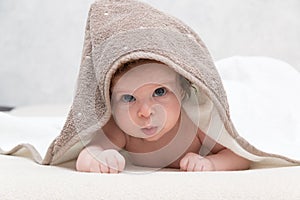 Portrait of sweet baby boy or girl with towel on head looking innocently being impressed about something and