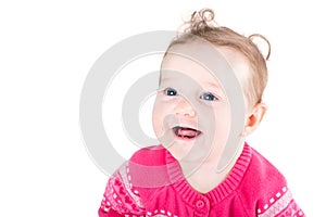 Portrait of a sweet baby girl with curly hair and blue eyes wearing a pink sweater with hearts pattern