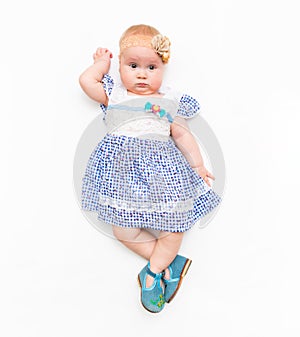Portrait of a sweet infant baby girl wearing dress and headband bow, isolated on white in studio