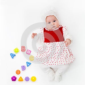 Portrait of a sweet infant baby girl wearing a red dress and bonnet,  on white in studio with number two from