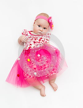 Portrait of a sweet infant wearing a pink tutu and headband bow, isolated on white