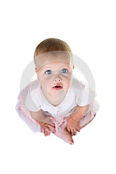 Portrait of a sweet infant wearing a pink tutu, necklace, and headband bow, isolated on white background