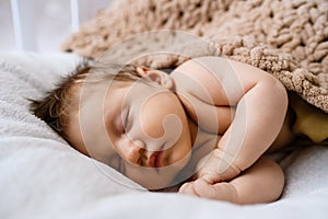 Portrait of sweet sleeping newborn baby in bed