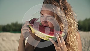 Portrait of sweet woman with waving hair eating watermelon outdoors cute irl enjoys her rest and smiles a slice of
