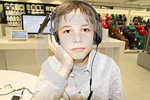 Portrait of a sweet young boy listening to music on headphones