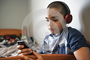 A Portrait of a sweet young boy listening to music on headphones