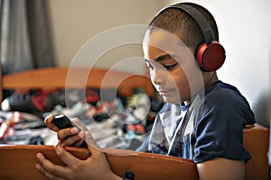 A Portrait of a sweet young boy listening to music on headphones