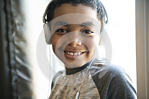 A Portrait of a sweet young boy listening to music on headphones