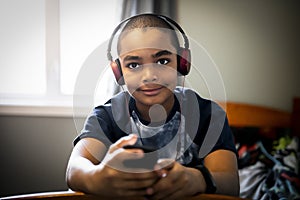 A Portrait of a sweet young boy listening to music on headphones