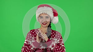 Portrait of sweety girl in Santa Claus hat is waiting in anticipation with pleasure. Green screen