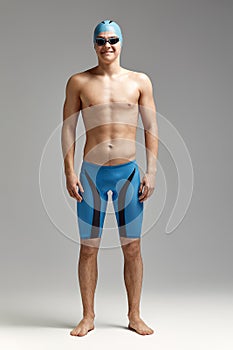 Portrait of a swimmer in a cap and mask, full-length portrait, young athlete swimmer wearing a cap and mask for swimming