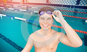 Portrait swimmer happy young man, background swimming pool blue water