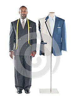 Portrait of tailor in formal wear standing besides a dummy