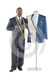 Portrait of tailor standing with mannequin