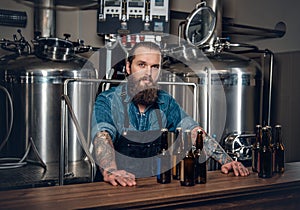 A man manufacturer presenting beer in the microbrewery.