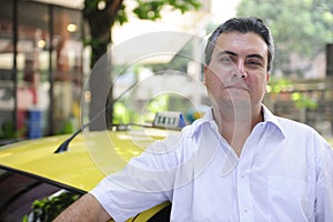 Portrait of a taxi driver with cab