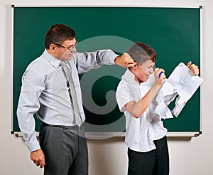 Portrait of a teacher catch the ear funny schoolboy with low discipline. Pupil very emotional, having fun and very happy, posing