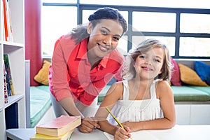 Portrait of teacher with girl in school library