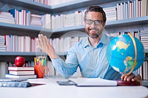 Portrait of teacher in library classroom. Handsome teacher in university library. Teachers Day. Teacher giving classes