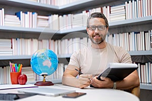 Portrait of teacher in library classroom. Handsome teacher in university library. Teachers Day. Teacher giving classes