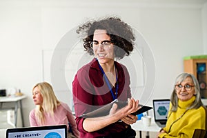 Portrait of teacher with seniors attending computer and technology education class.