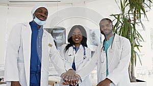 Portrait of team of smiling doctors looking at camera in medical office.