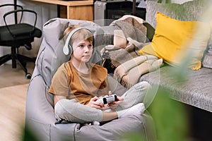 Portrait of teen boy actively and recklessly playing video game with joystick