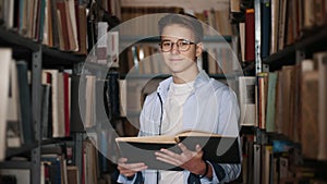Portrait of a teen boy with a book in the library