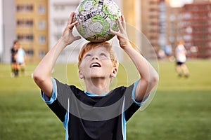 Portrait of teen boy having fun with ball in the stadium