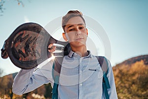 Portrait of a Teen boy holding a skateboard. Mountains and sky in the background