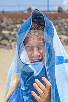 Portrait of a teen boy with a towel over his head