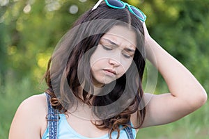 Portrait of teen girl busy problems in summer nature