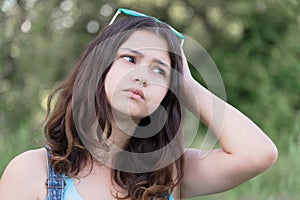 Portrait of teen girl busy problems in summer nature