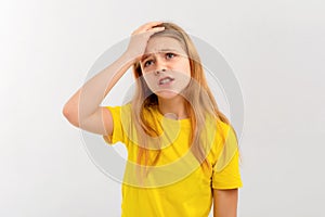 Portrait of teen girl having headache. Young woman touches her head and grimaces from migraine, feels sick dizzy, stands