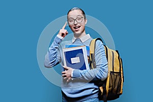 Portrait of teen girl high school student on blue studio background