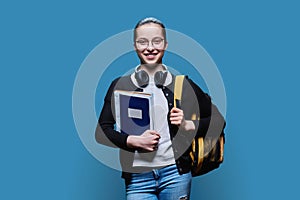 Portrait of teen girl high school student on blue studio background