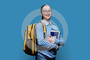 Portrait of teen girl high school student on blue studio background