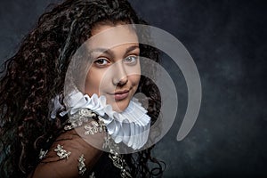 Portrait of a teen girl with long dark curly hair wearing a ruffled collar