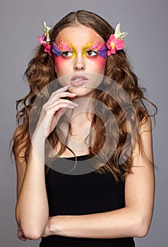 Portrait of teen girl with orchid flower in wavy hair