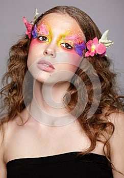 Portrait of teen girl with orchid flower in wavy hair