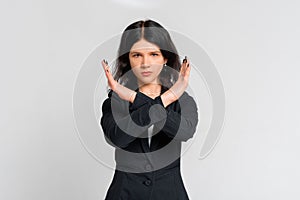 Portrait of teen girl showing stop sign, showing crossed arms gesture, prohibit action, rejecting smth with angry serious face,