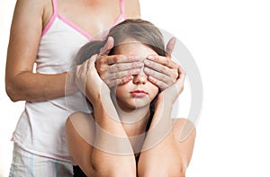 Portrait of a teen girl surprising her mother by covering eyes