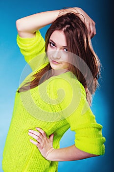 Portrait teen girl in vivid colour sweater on blue