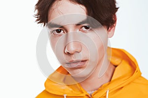 Portrait of a teen guy in a yellow raincoat brunette in the studio