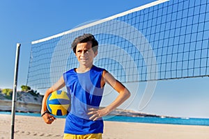 Beach volleyball player with ball next to the net