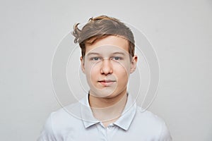 Portrait of a teenage boy blond on a white background close-up