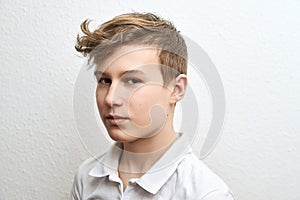 Portrait of a teenage boy blond on a white background close-up