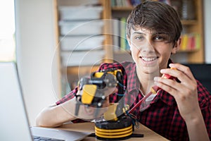 Portrait Of Teenage Boy Building Robotic Arm At School