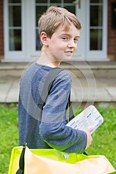 Portrait Of Teenage Boy Delivering Newspaper To House