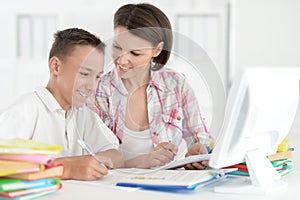 Portrait of Teenage boy doing homework with computer